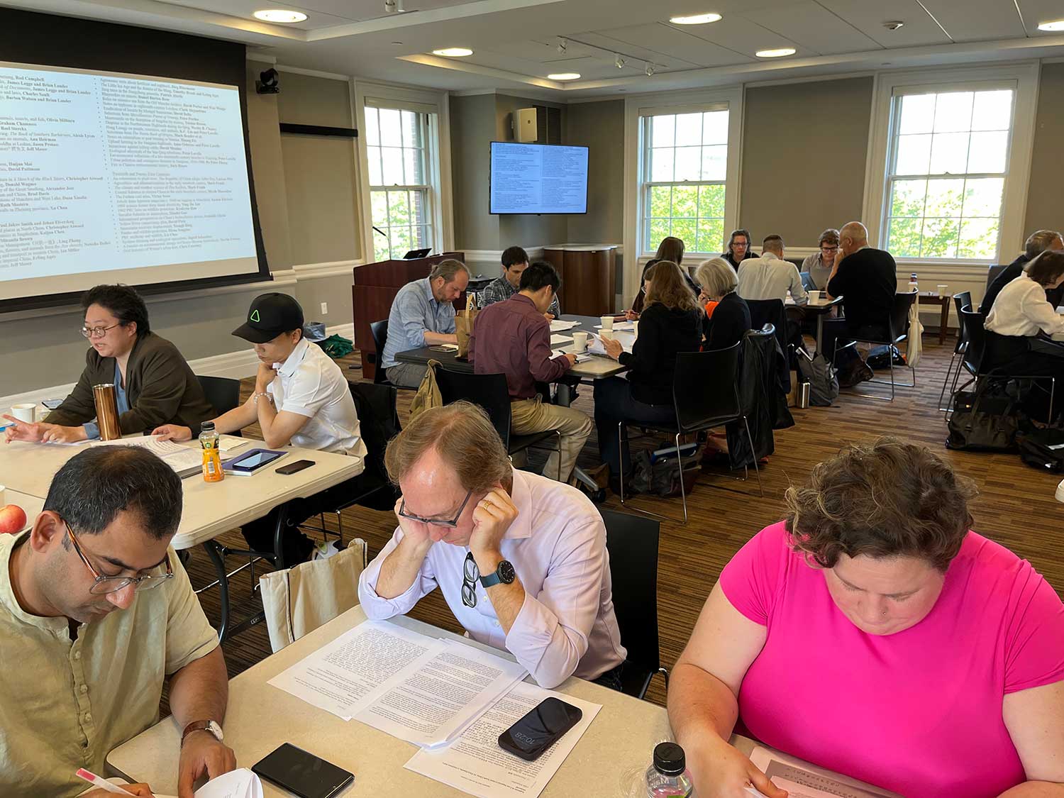 Scholars sitting at tables during workshop.